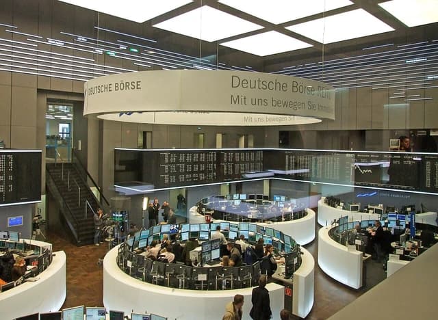 Overview of the trading floor at the Deutsche Börse with traders at desks and monitors.