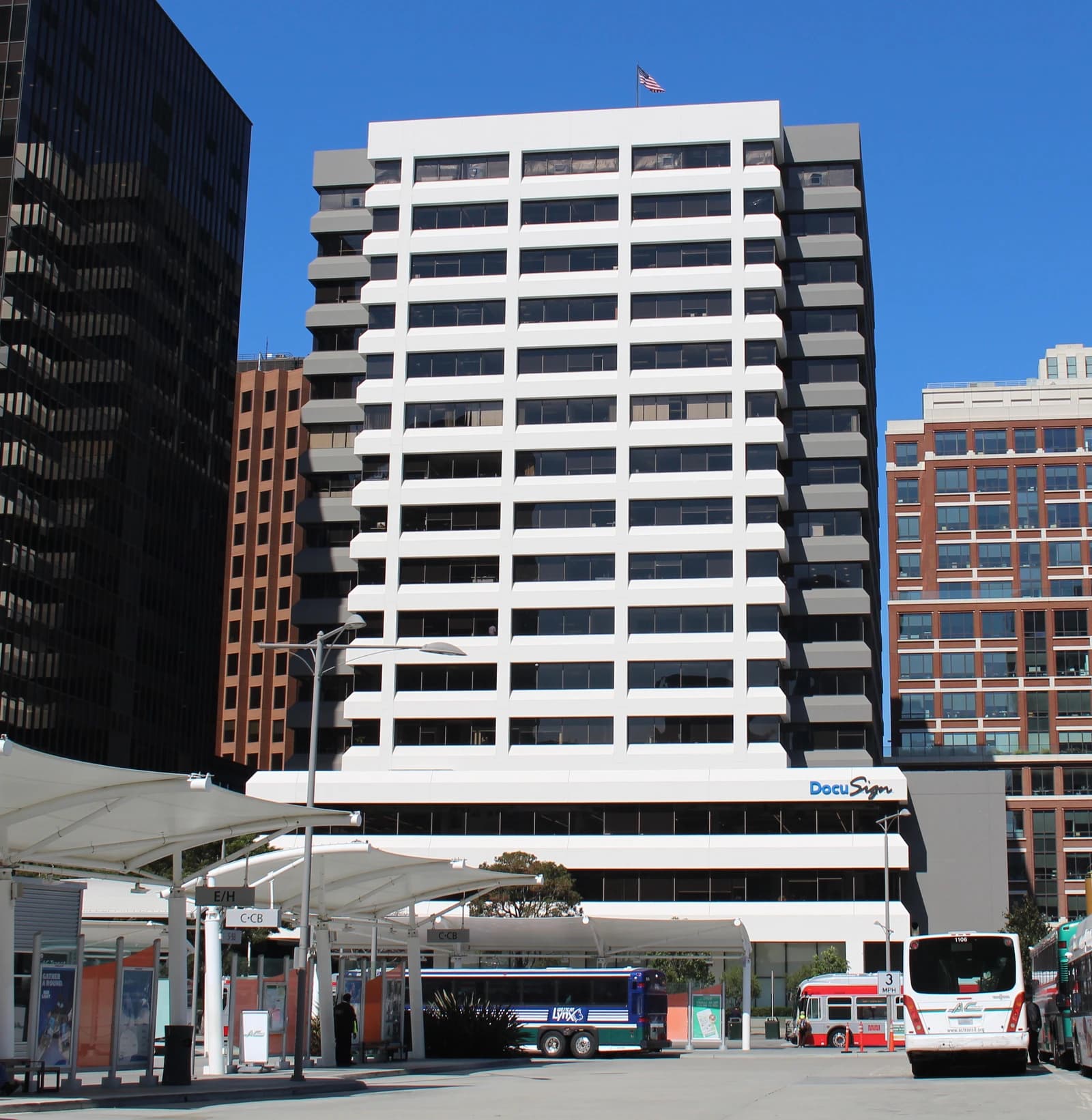 DocuSign's headquarters, a multi-story white building, seen from an outdoor public space.