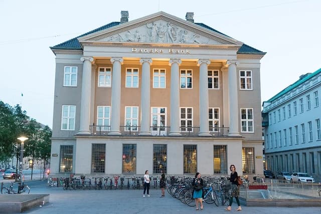 Erichsen Mansion, Danske Bank headquarters, in Copenhagen, Denmark, with people walking outside.