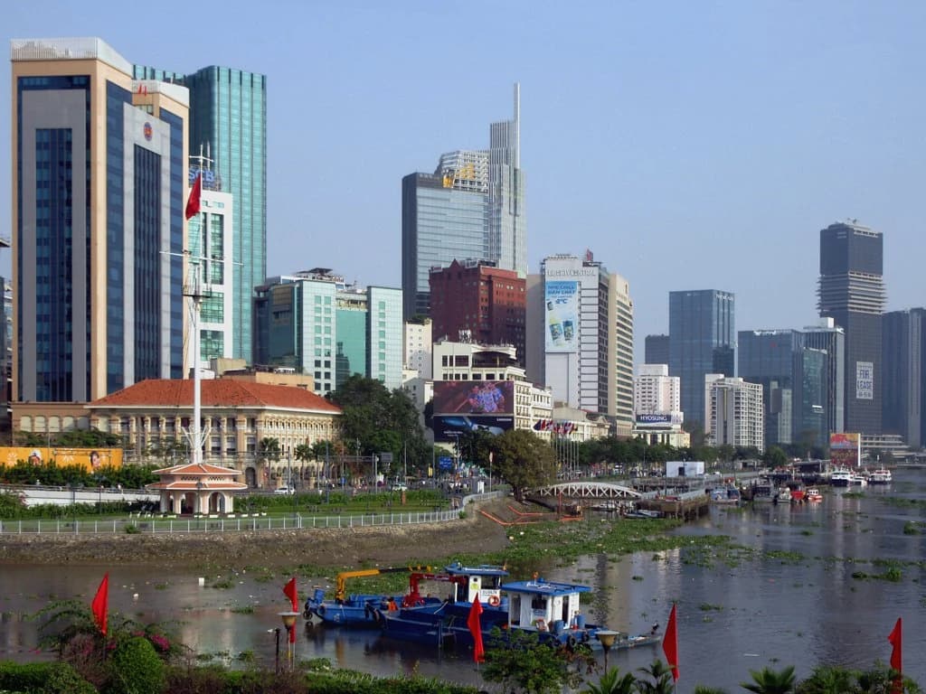 Skyline of Ho Chi Minh City along a river with various buildings.