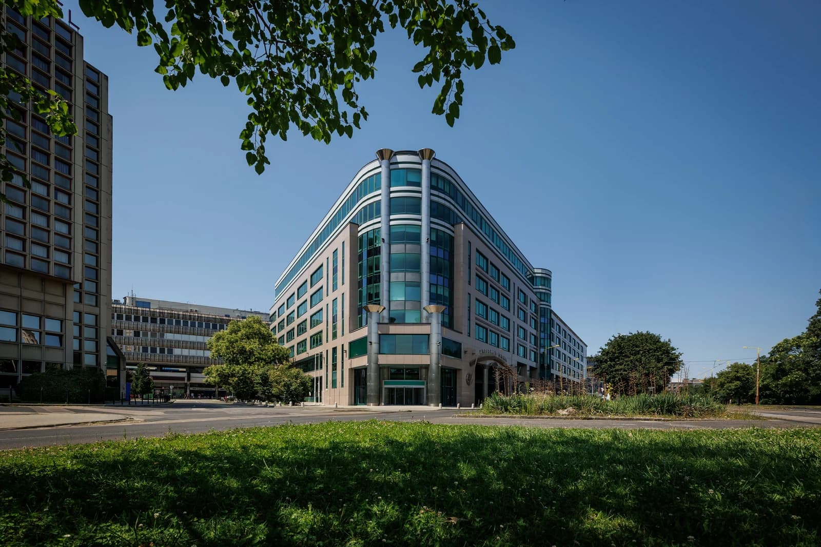 Exterior view of the 4iG Nyrt. Headquarters building, a modern office building with green and grey facade elements, located in Budapest.