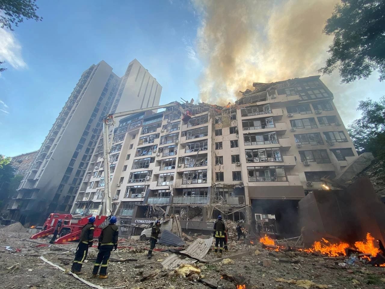 Firefighters responding to a severely damaged residential building in Kyiv after shelling.
