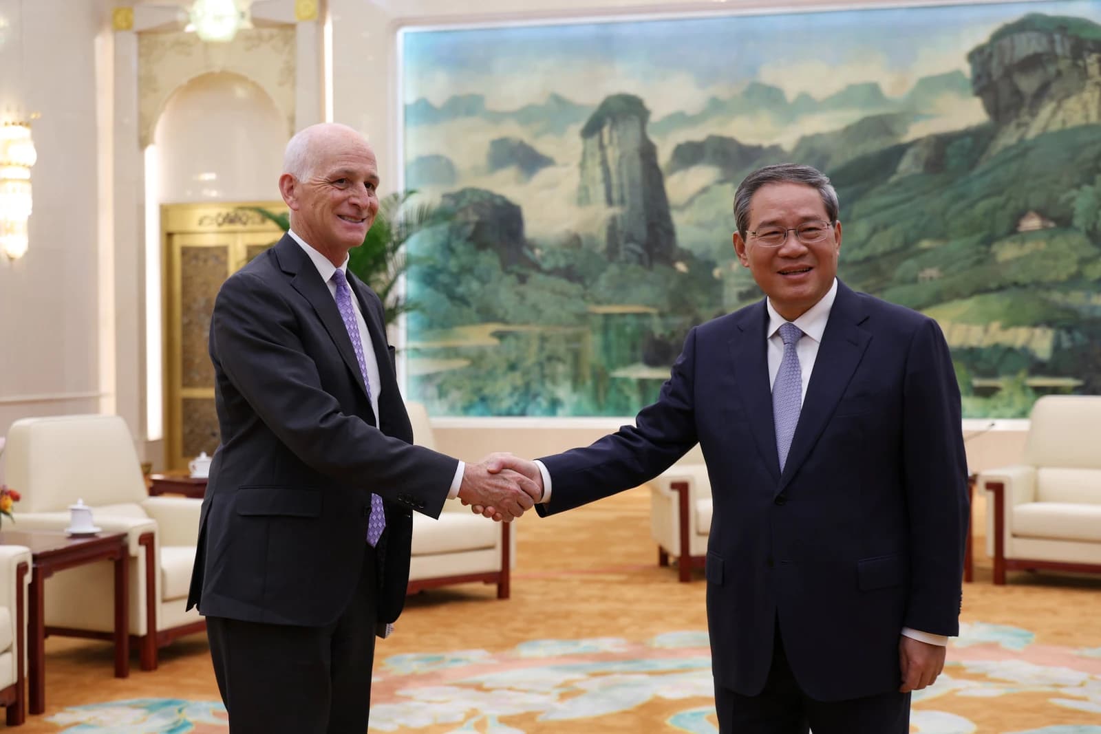 Rep. Adam Smith shaking hands with Premier of China Li Qiang indoors.