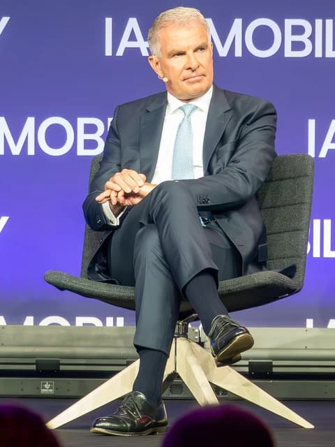 Carsten Spohr, CEO of Lufthansa AG, sitting on a chair at the IAA Summit 2023.