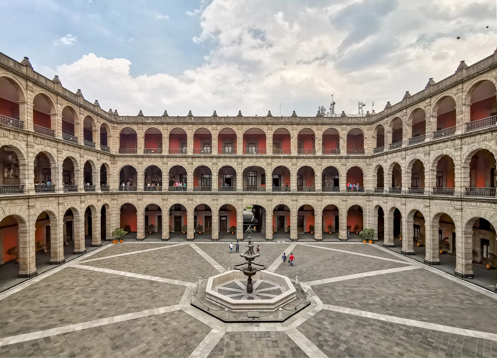 The central patio of the National Palace in Mexico City, featuring a fountain and arched corridors.