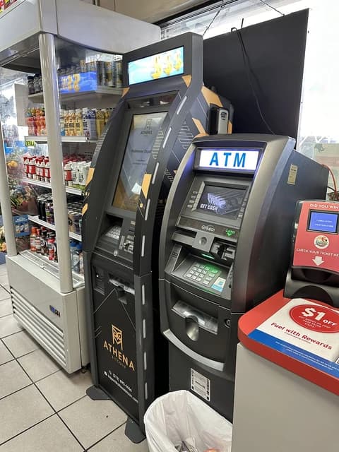 An Athena Bitcoin ATM and a traditional ATM stand side-by-side inside a gas station.