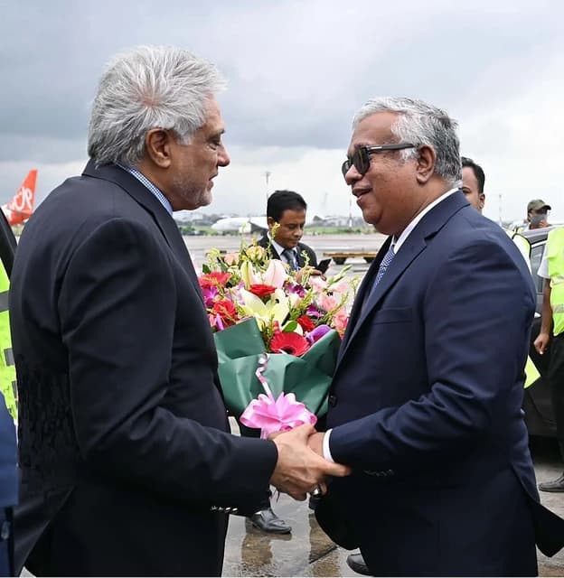 Ishaq Dar, Pakistani politician, shaking hands with an official outdoors.