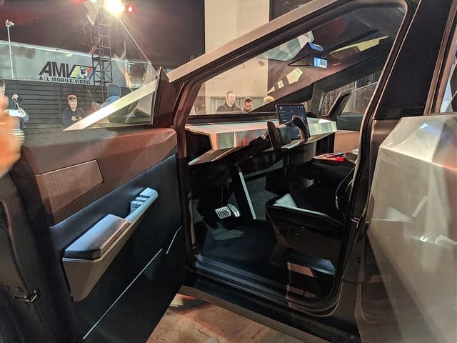 The open driver's side door of the Tesla Cybertruck, revealing the interior.