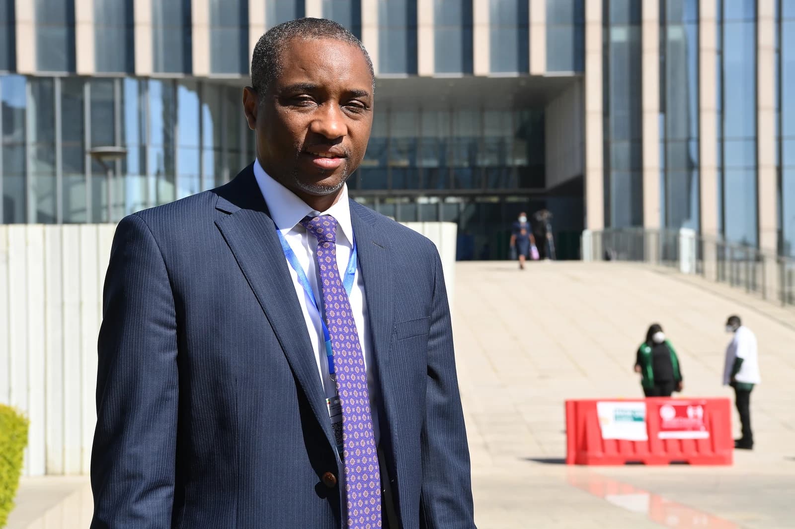 Abdou Salam Ndiath, African official, standing outdoors in front of a building.