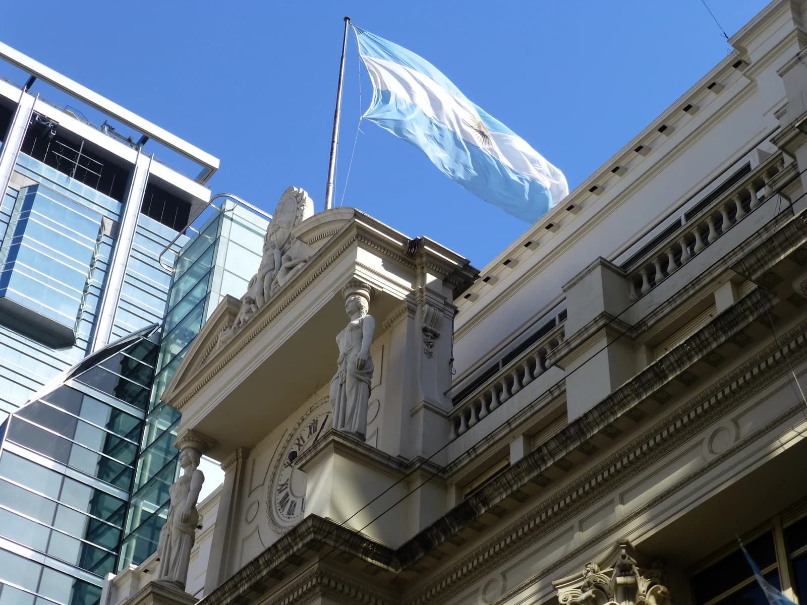 Exterior view of the Central Bank of the Argentine Republic building with the Argentinian flag flying.