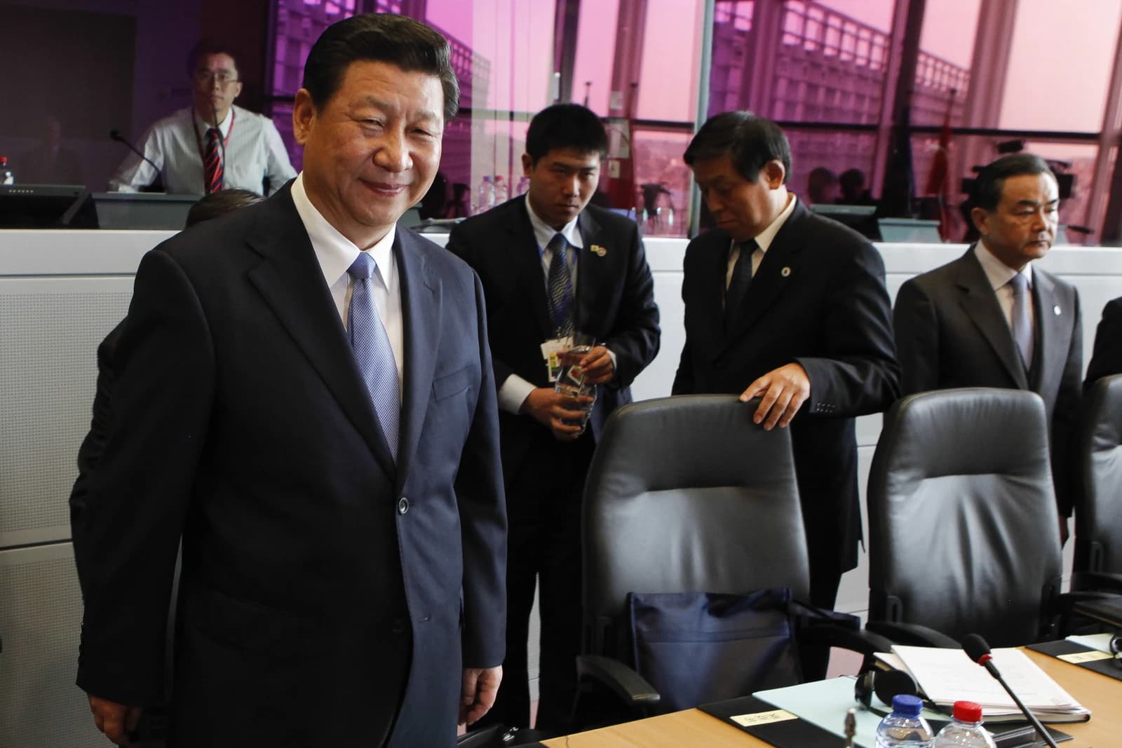 Xi Jinping, President of China, smiling at a meeting table.