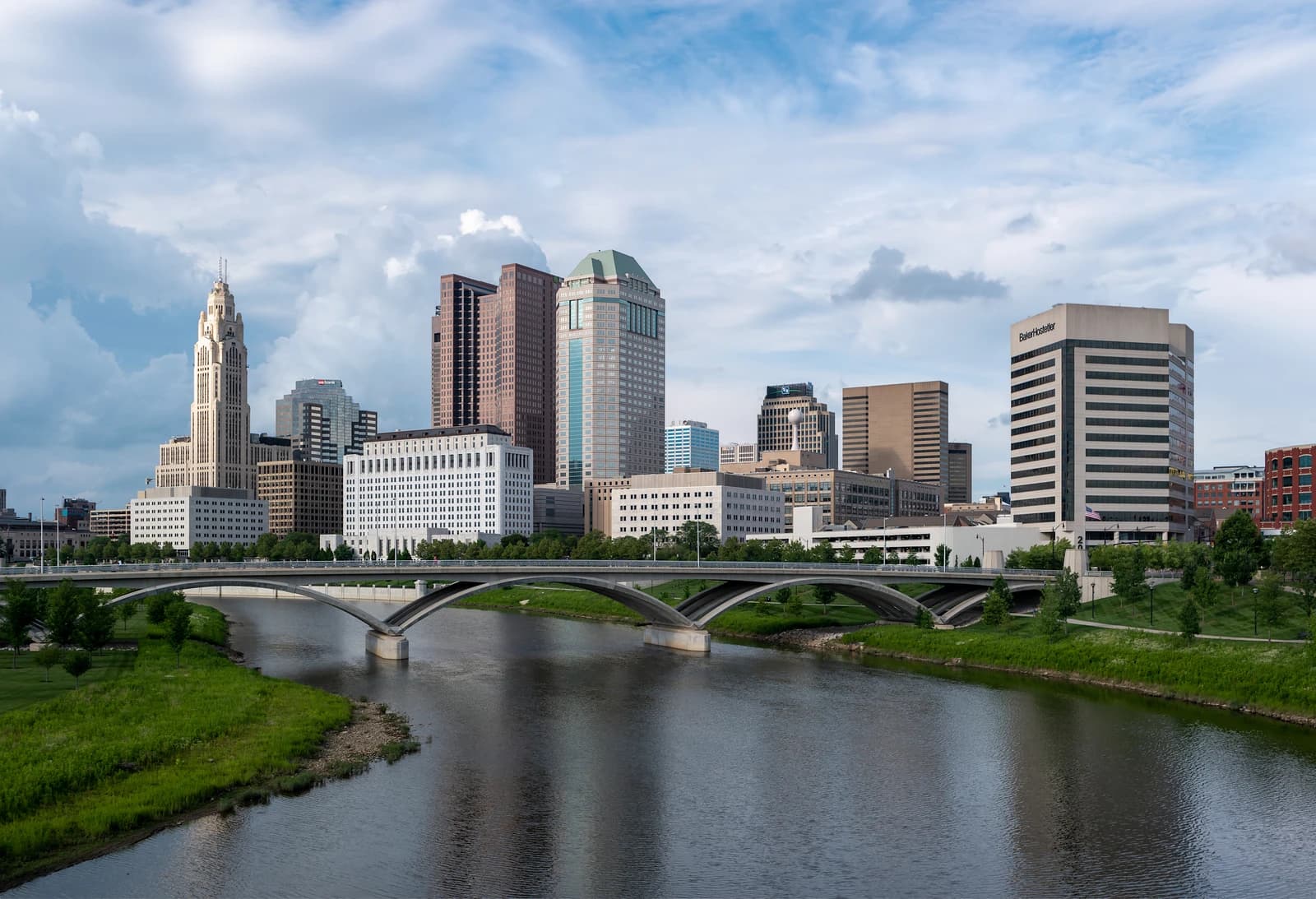 Columbus, Ohio, skyline with downtown buildings and a bridge spanning a river.