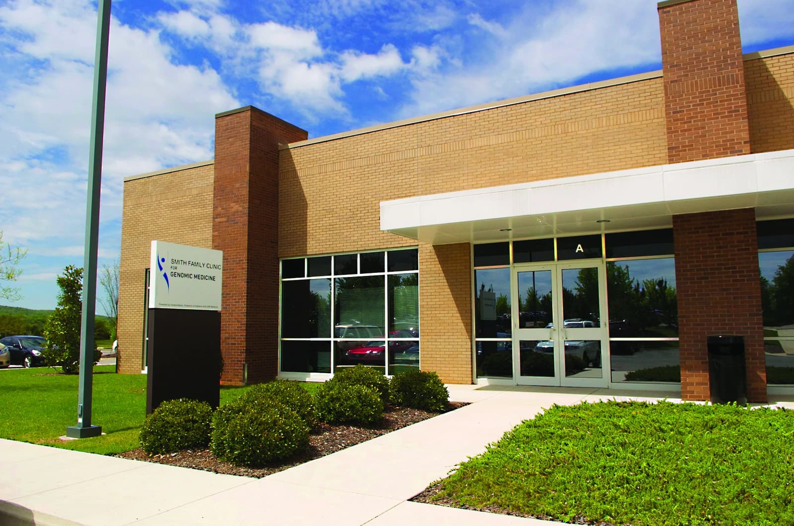 Exterior of the Smith Family Clinic for Genomic Medicine building with entrance and sign.