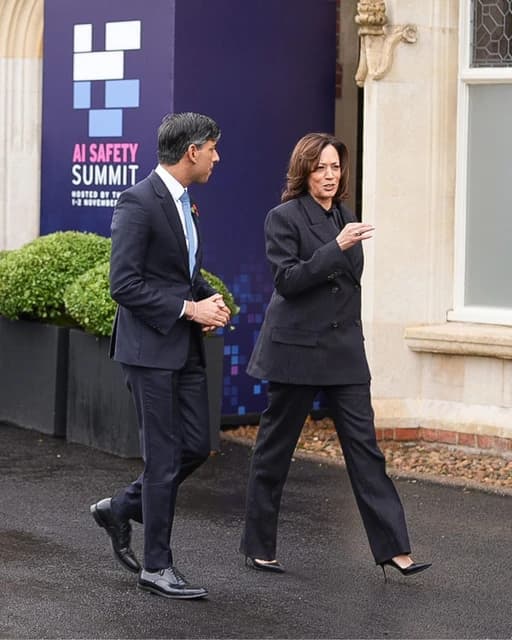 Vice President Kamala Harris and UK Prime Minister Rishi Sunak walk outside a building.
