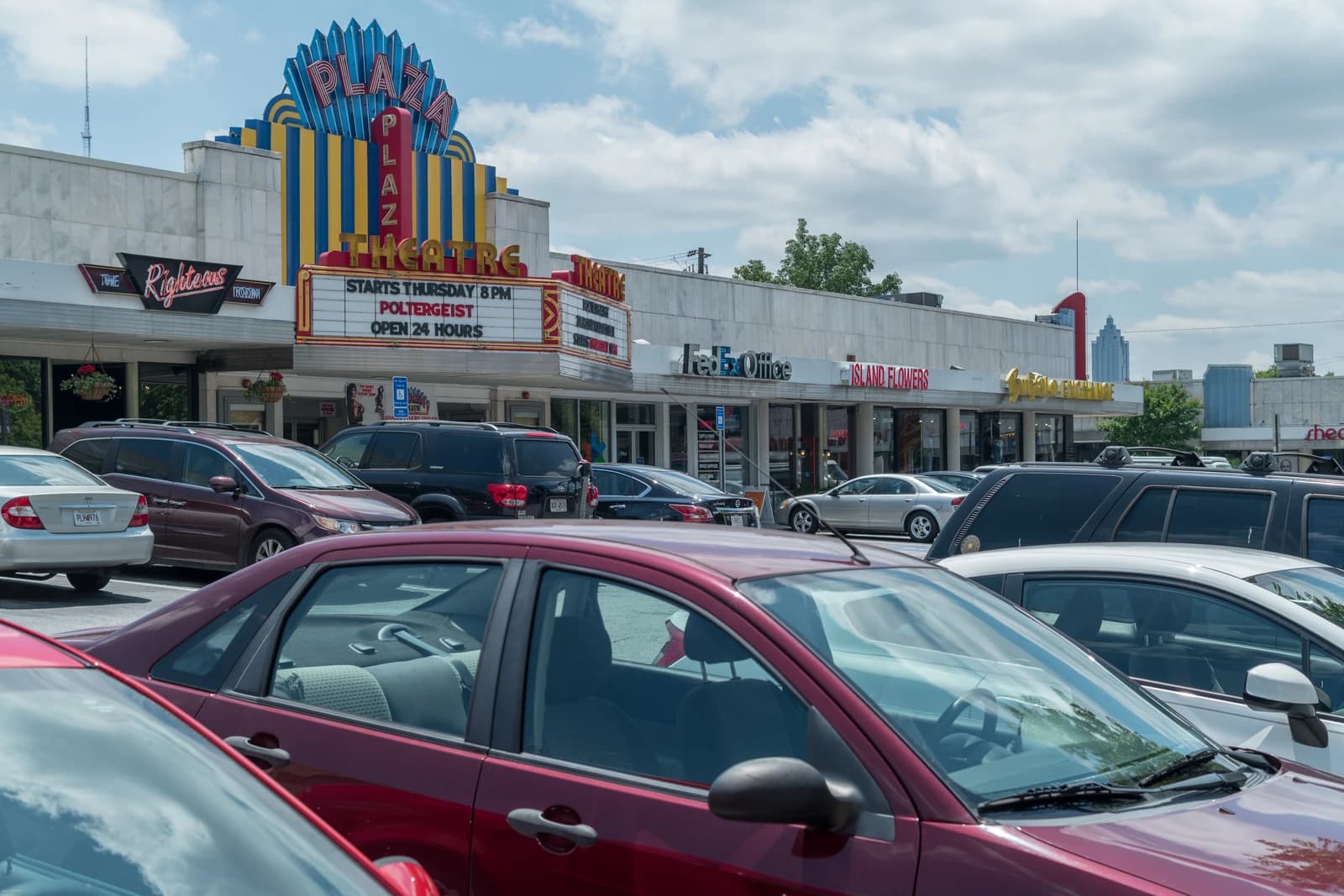 Briarcliff Plaza shopping center in Atlanta, Georgia, with various storefronts and parked cars.