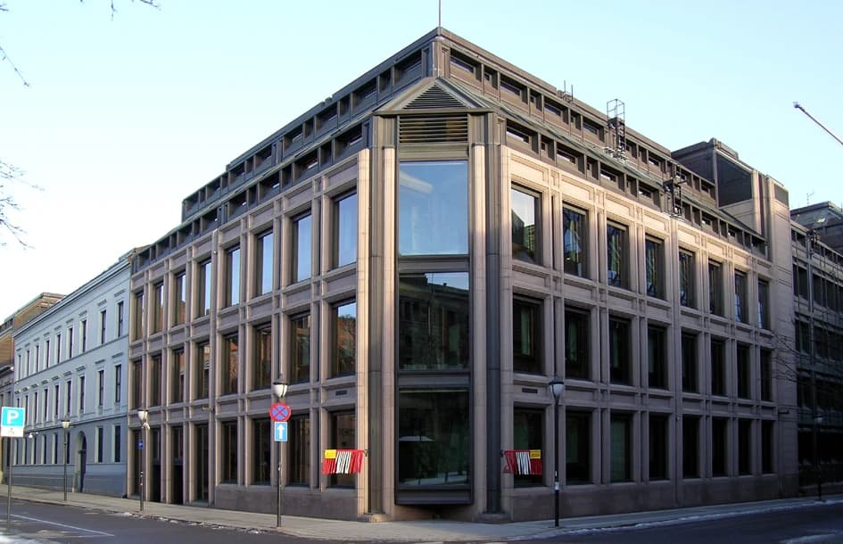 Norges Bank headquarters building with multiple windows and corner glass section.
