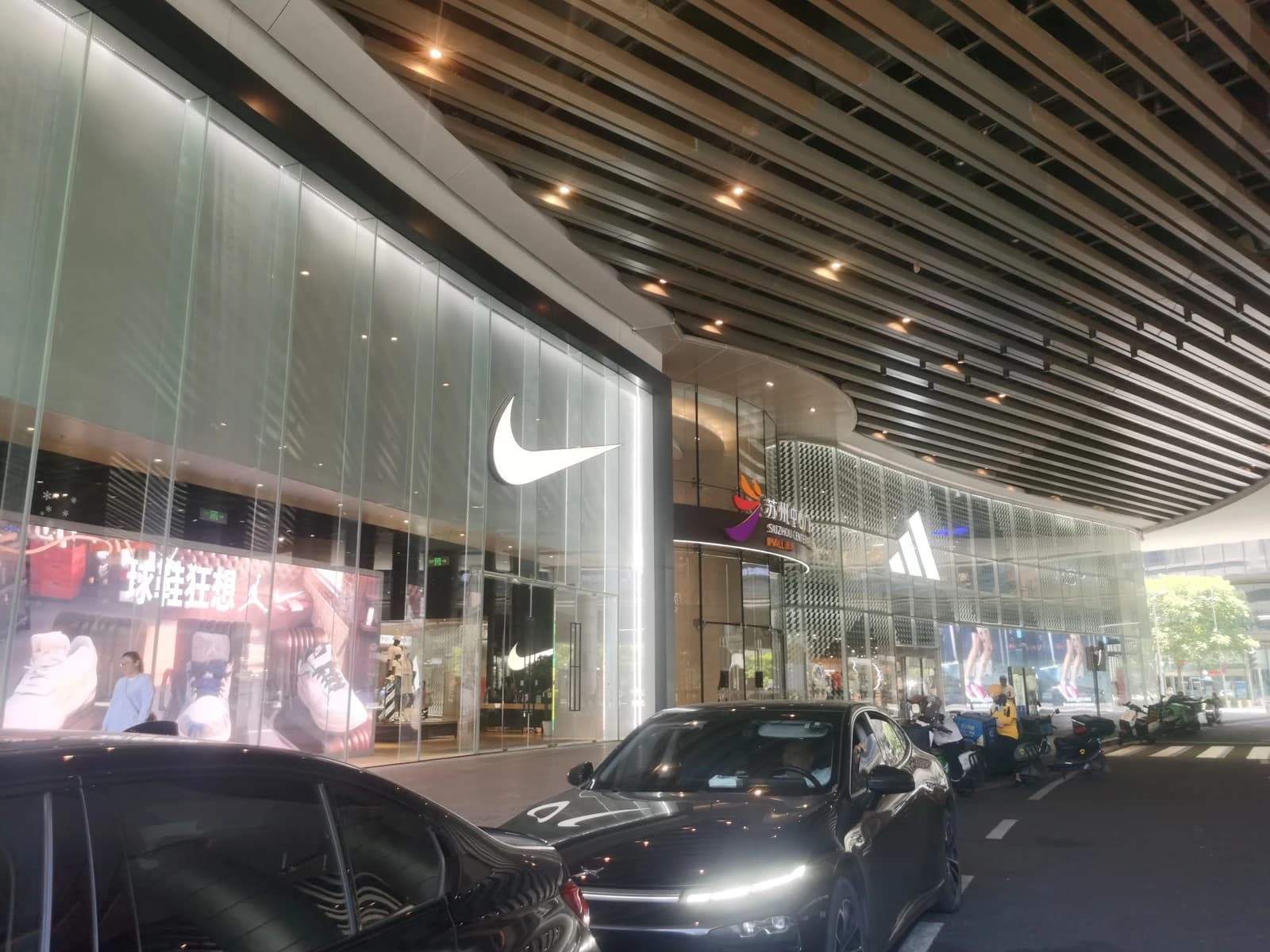 Exterior view of Nike and Adidas stores at a modern shopping mall.