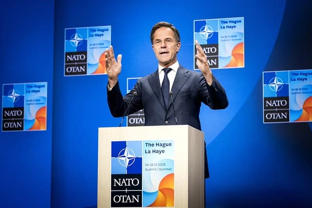 Mark Rutte, Prime Minister of the Netherlands, speaks at a podium with NATO logos.