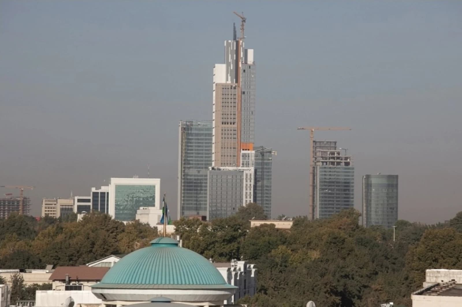 City skyline of Tashkent with modern high-rise buildings and construction cranes.