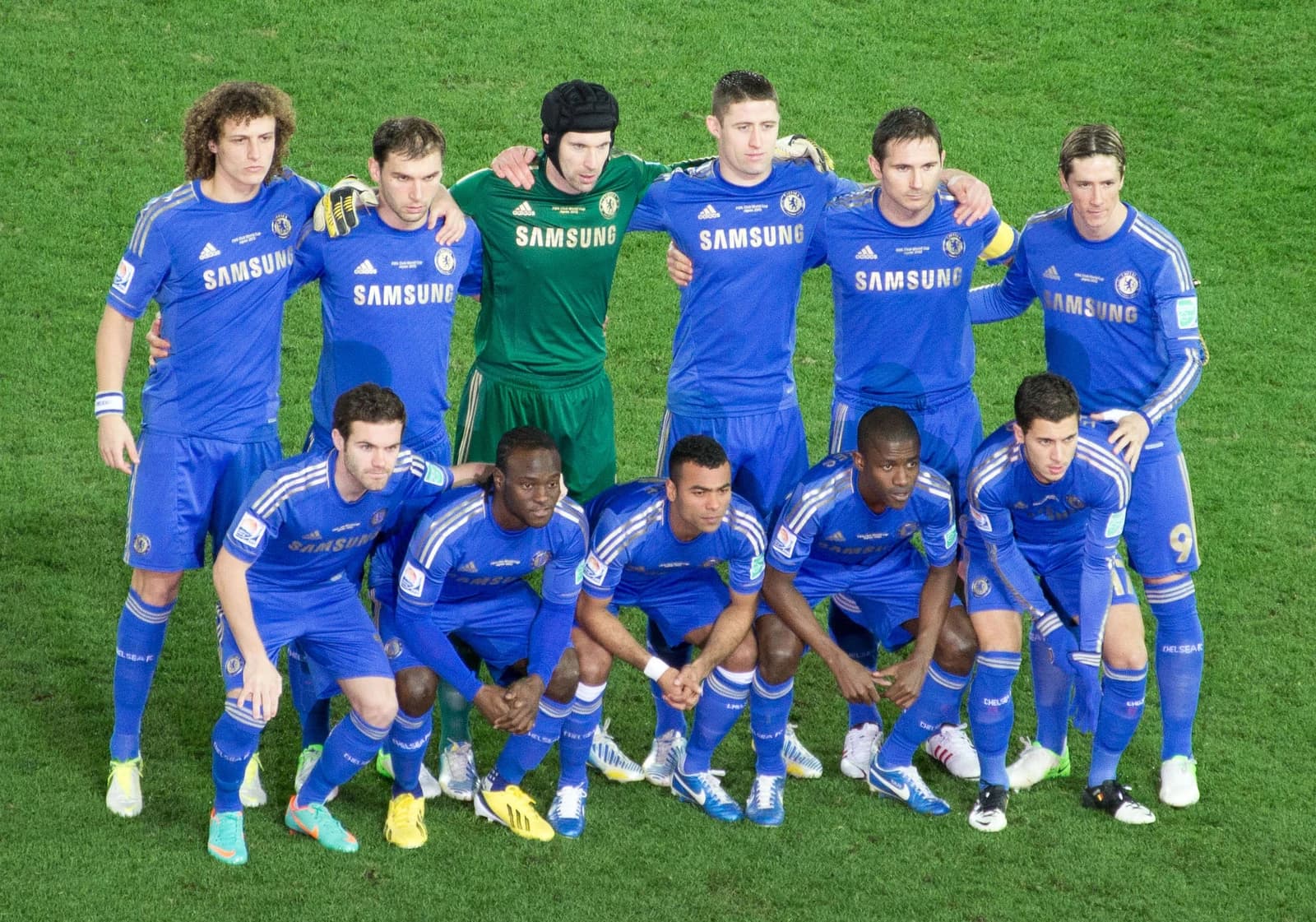 Chelsea FC team, including David Luiz and Frank Lampard, posing on a football pitch.