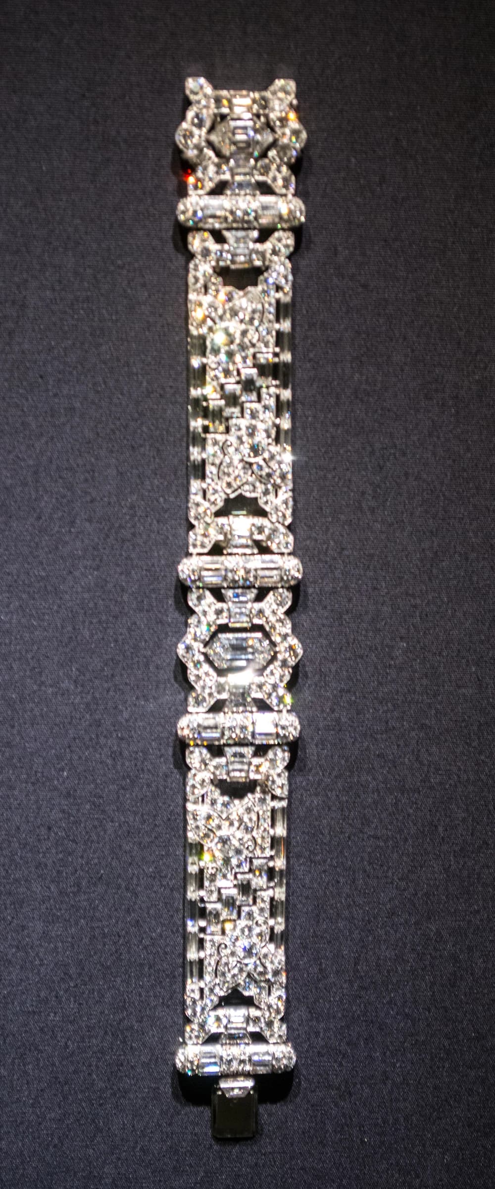 Diamond and platinum asymmetrical bracelet by Oscar Heyman and Bros on a dark background.