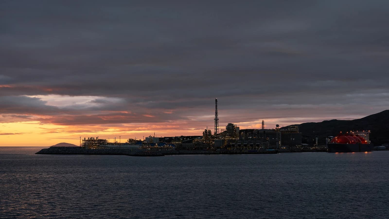 Melkøya LNG Terminal and a liquefied natural gas carrier at sunset.