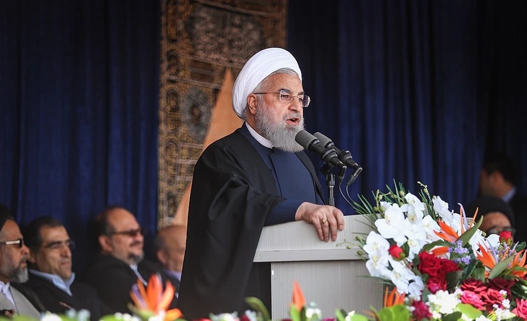 Hassan Rouhani, former President of Iran, speaking at a podium in Tabriz.