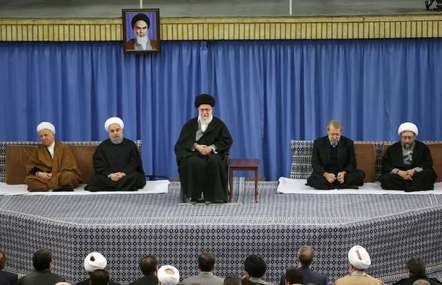 Hasan Rouhani, former President of Iran, sits with other government officials during a meeting.