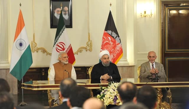 Hasan Rouhani, then-President of Iran, sits at a table between Narendra Modi and Mohammad Ashraf Ghani.