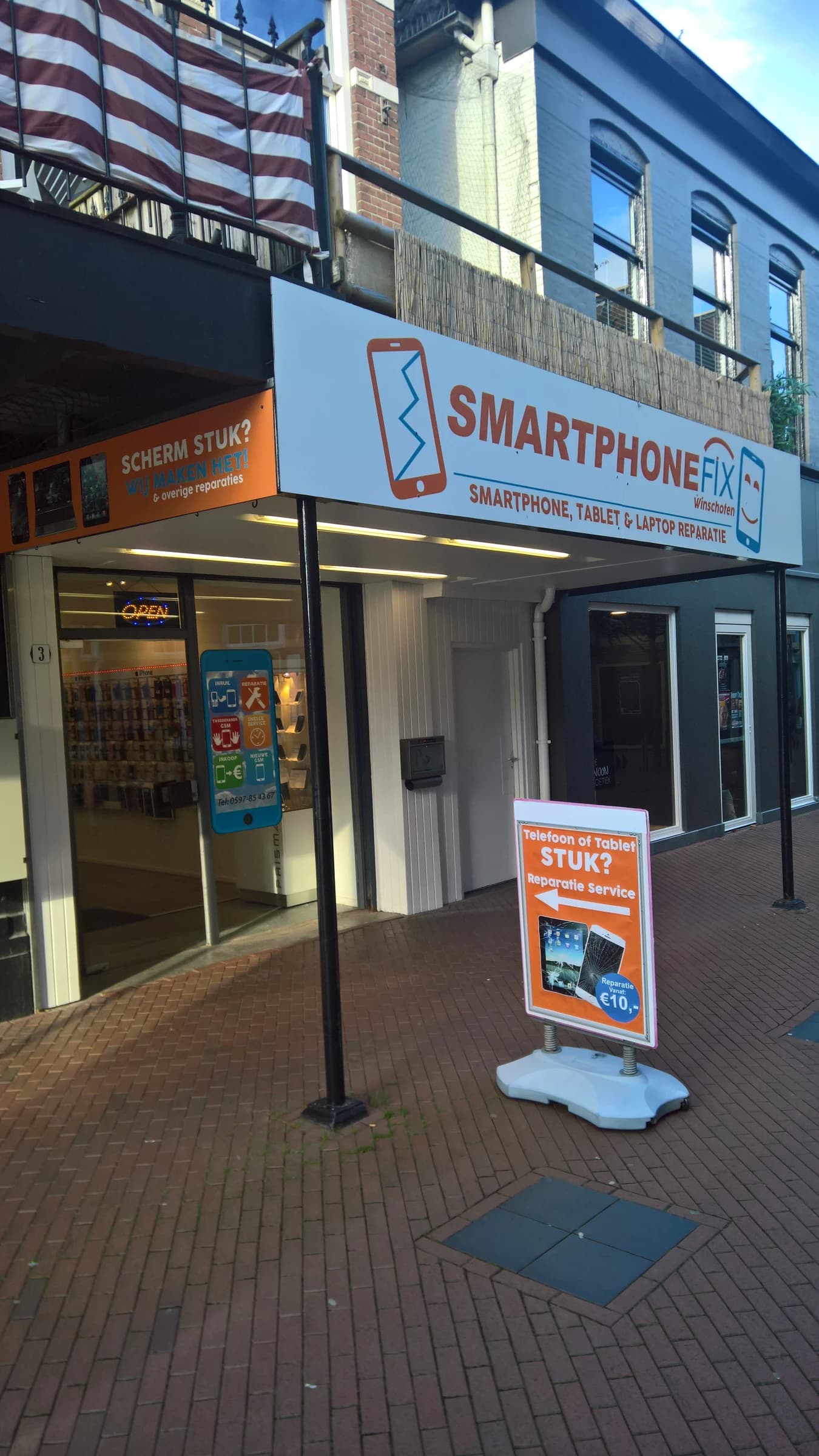 Exterior view of a 'SmartphoneFix' repair shop with signage in Winschoten, Netherlands.