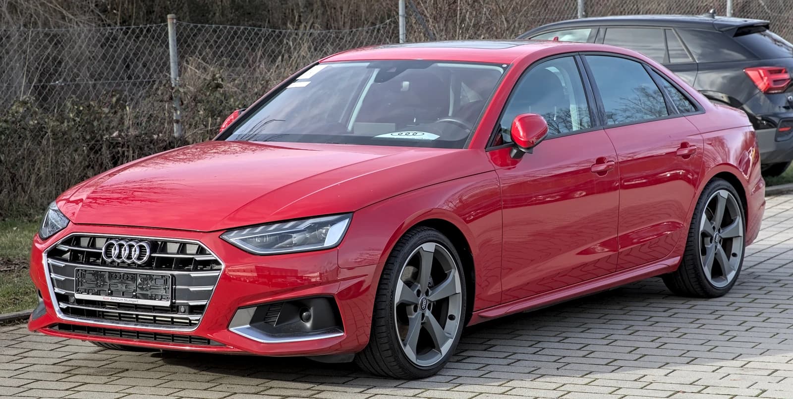 Red Audi A4 B9 sedan facelift model parked on a paved surface outdoors.