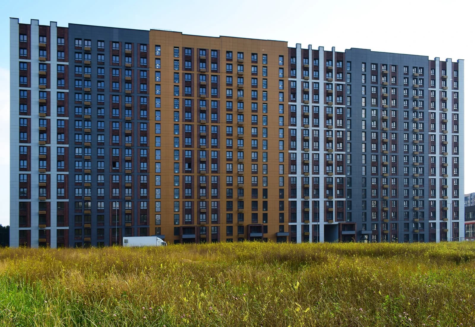 A large, modern residential building with multiple colored sections in Moscow.