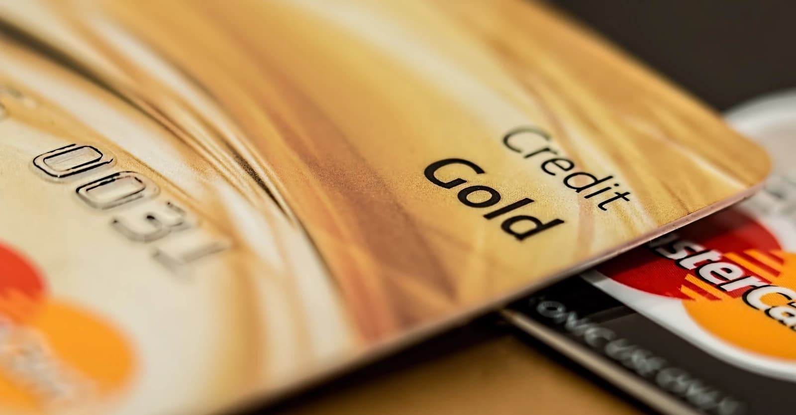 Close-up of a gold colored credit card partially covering another credit card.