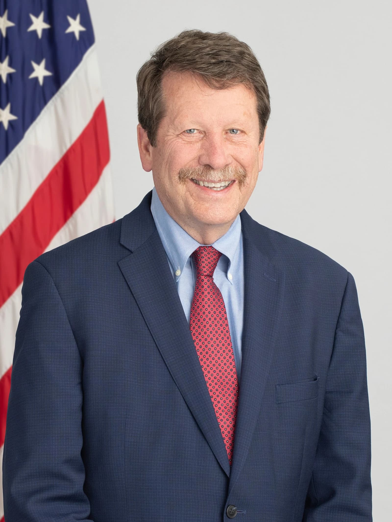 Robert M. Califf, FDA Commissioner, stands in front of an American flag.