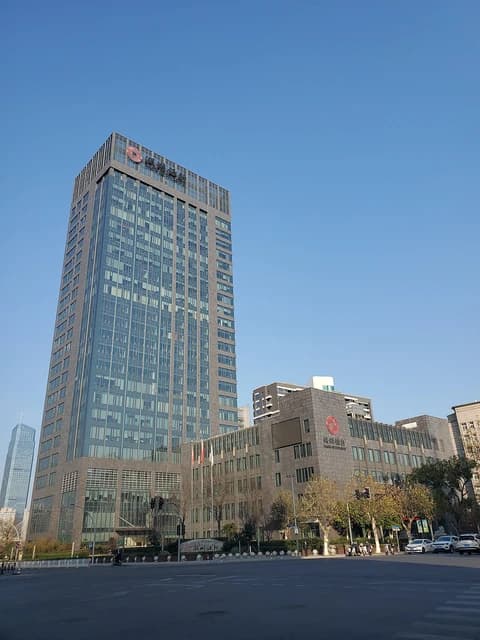 Headquarters building for the Bank of Huzhou in Huzhou, China, against a blue sky.