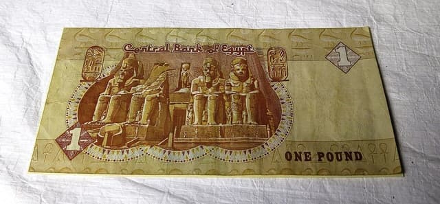 Egyptian one-pound banknote with ancient Egyptian statues and 'Central Bank of Egypt' text.
