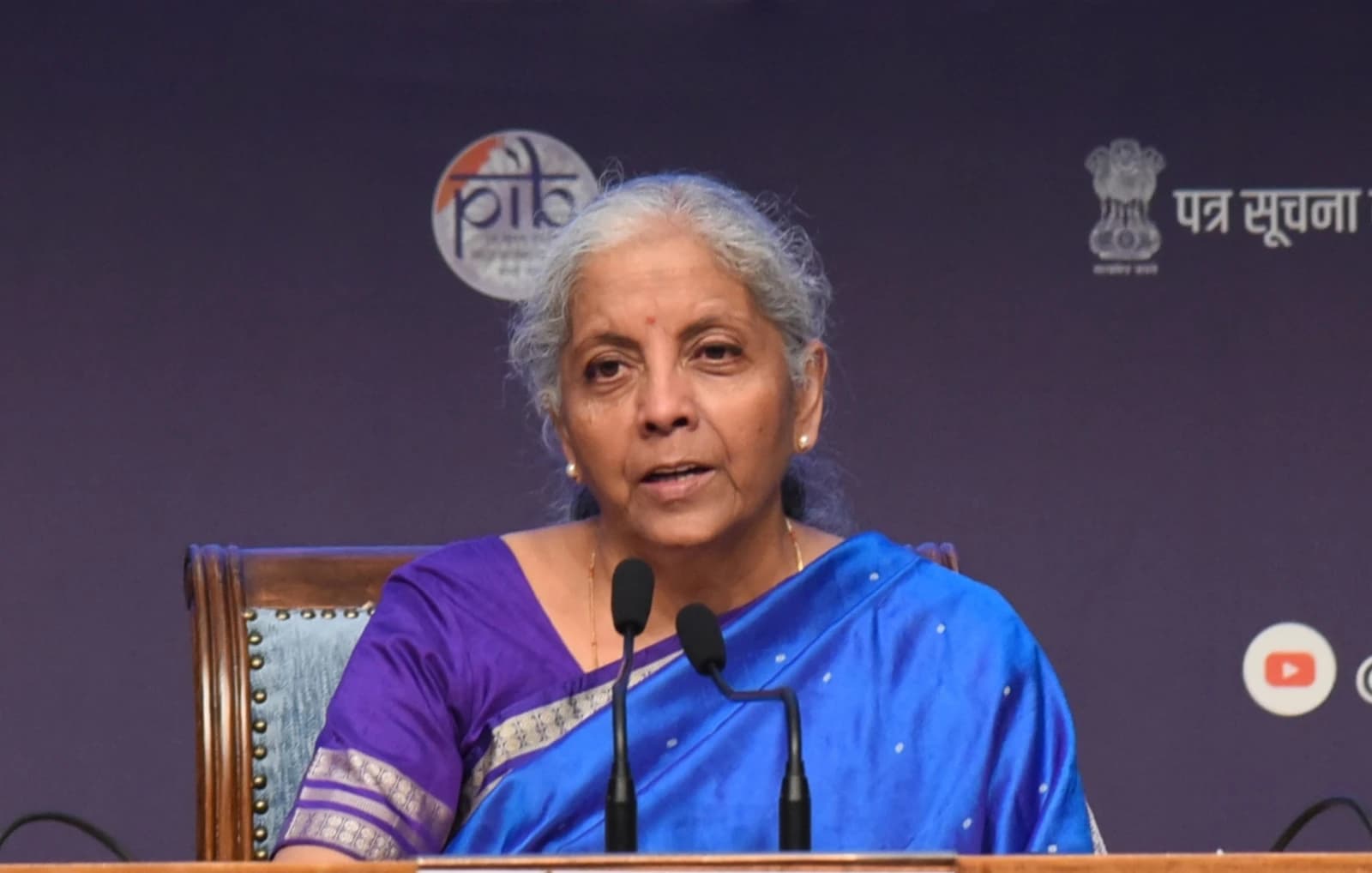 Nirmala Sitharaman, Minister of Finance, speaking at two microphones.