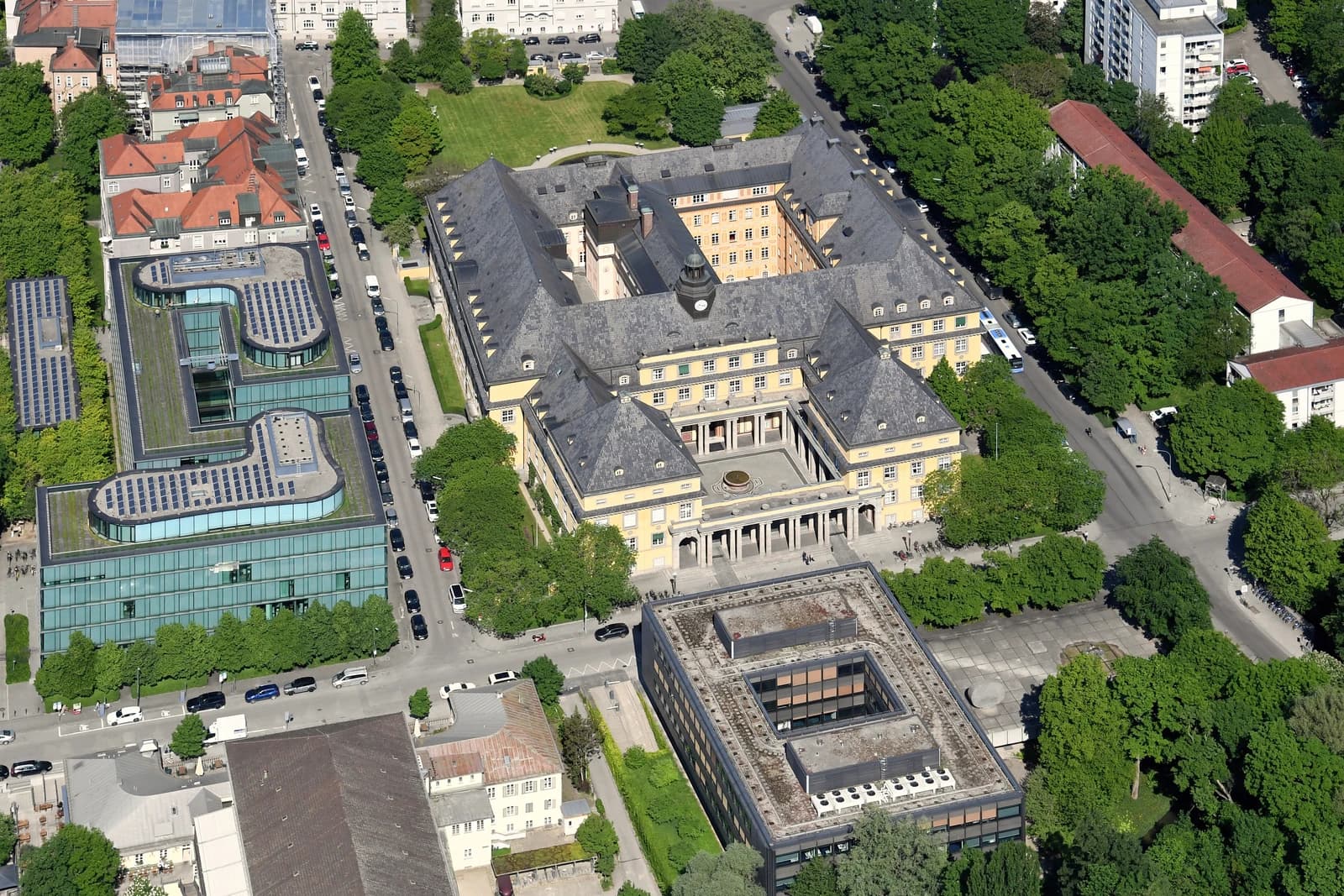 Aerial view of the Munich Re headquarters building complex with surrounding streets and trees.