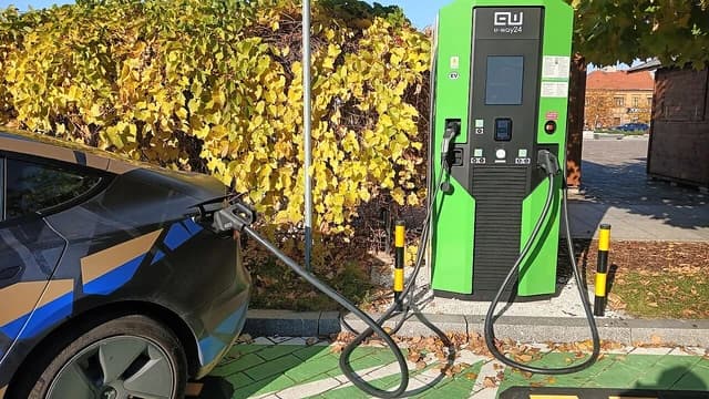Tesla Model 3 charging at an electric vehicle charging station.