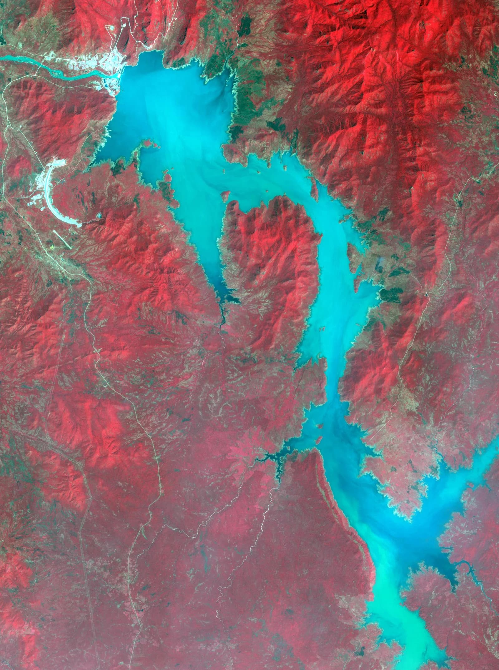 Satellite image showing the Grand Ethiopian Renaissance Dam and the surrounding landscape with water in bright blue.