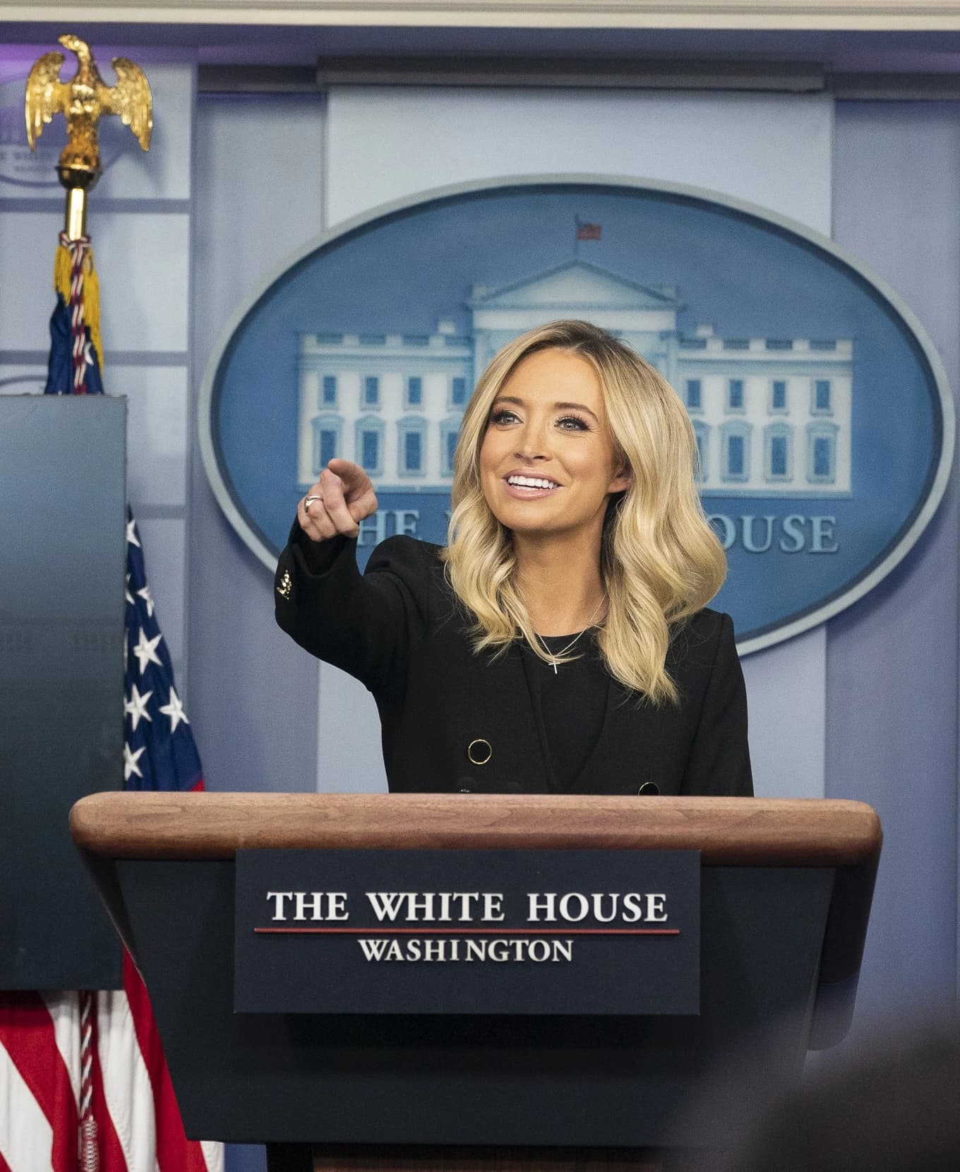 Kayleigh McEnany, former White House Press Secretary, speaks from a podium at a press briefing.