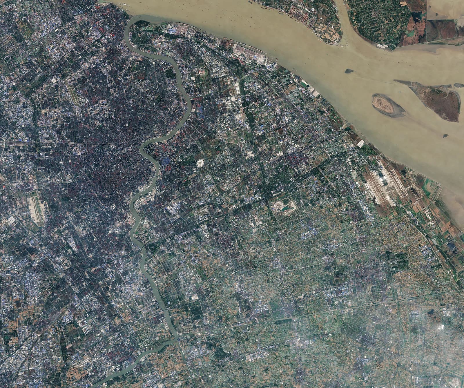 An aerial satellite view of the densely populated city of Shanghai, China, with a river flowing through it.