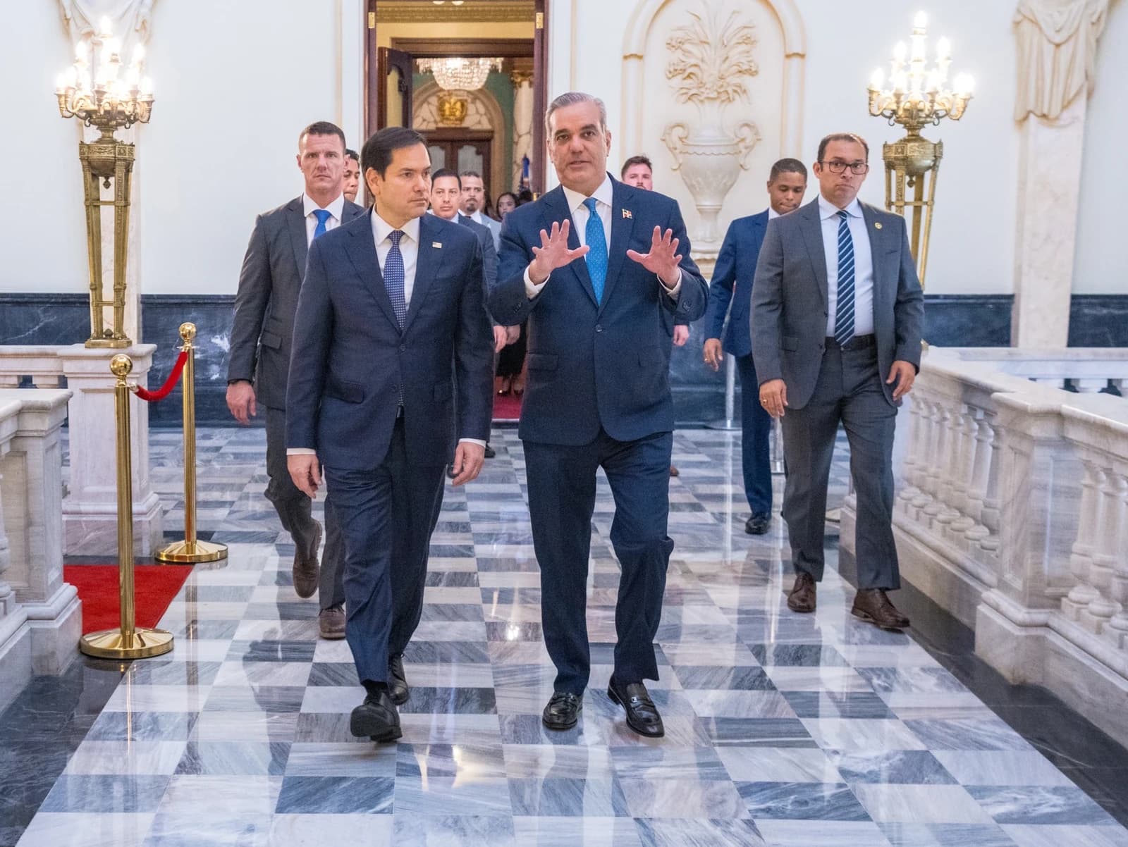 Senator Marco Rubio and President Luis Abinader walk together in a formal building.