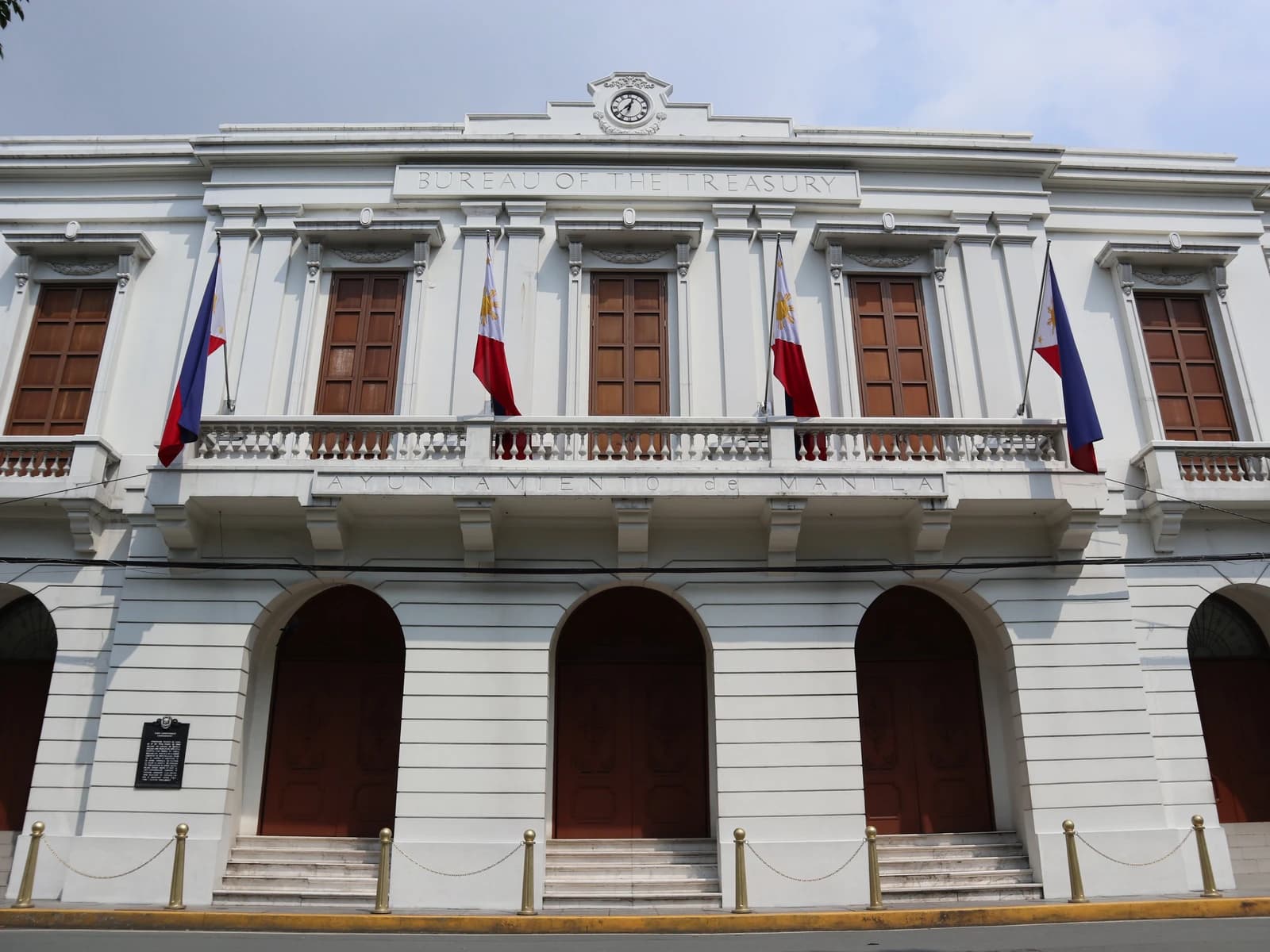 Bureau of the Treasury building facade with flags and ornate windows.