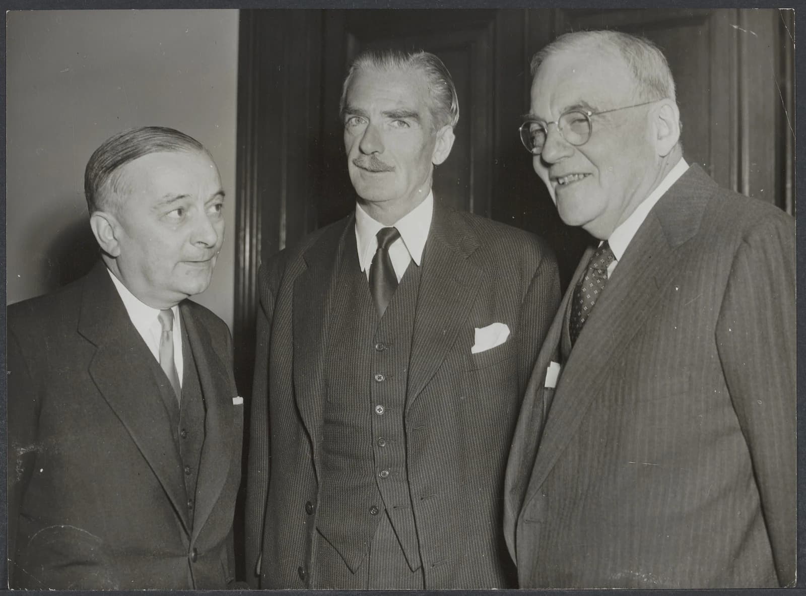 Georges Bidault, Anthony Eden, and John Foster Dulles standing in a group.