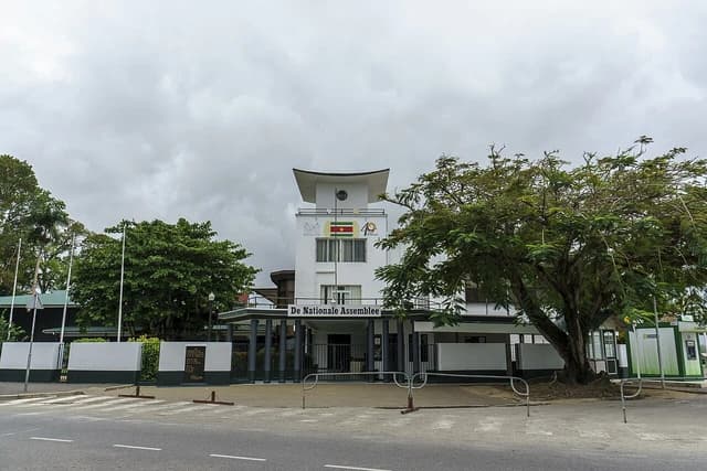 The National Assembly Building, a white building, on a cloudy day in Paramaribo, Suriname.