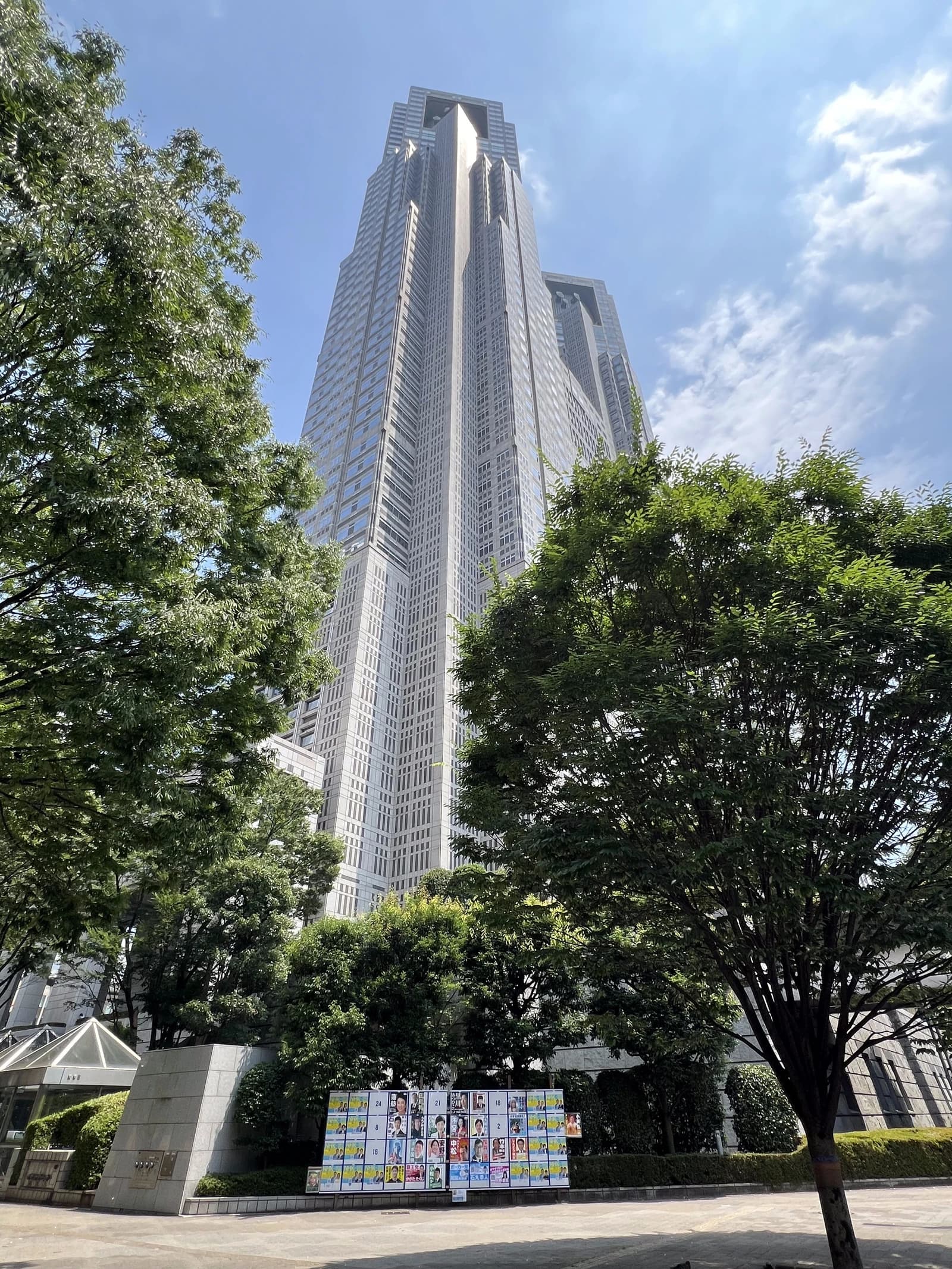Tokyo Metropolitan Government Building soaring above an election bulletin board.