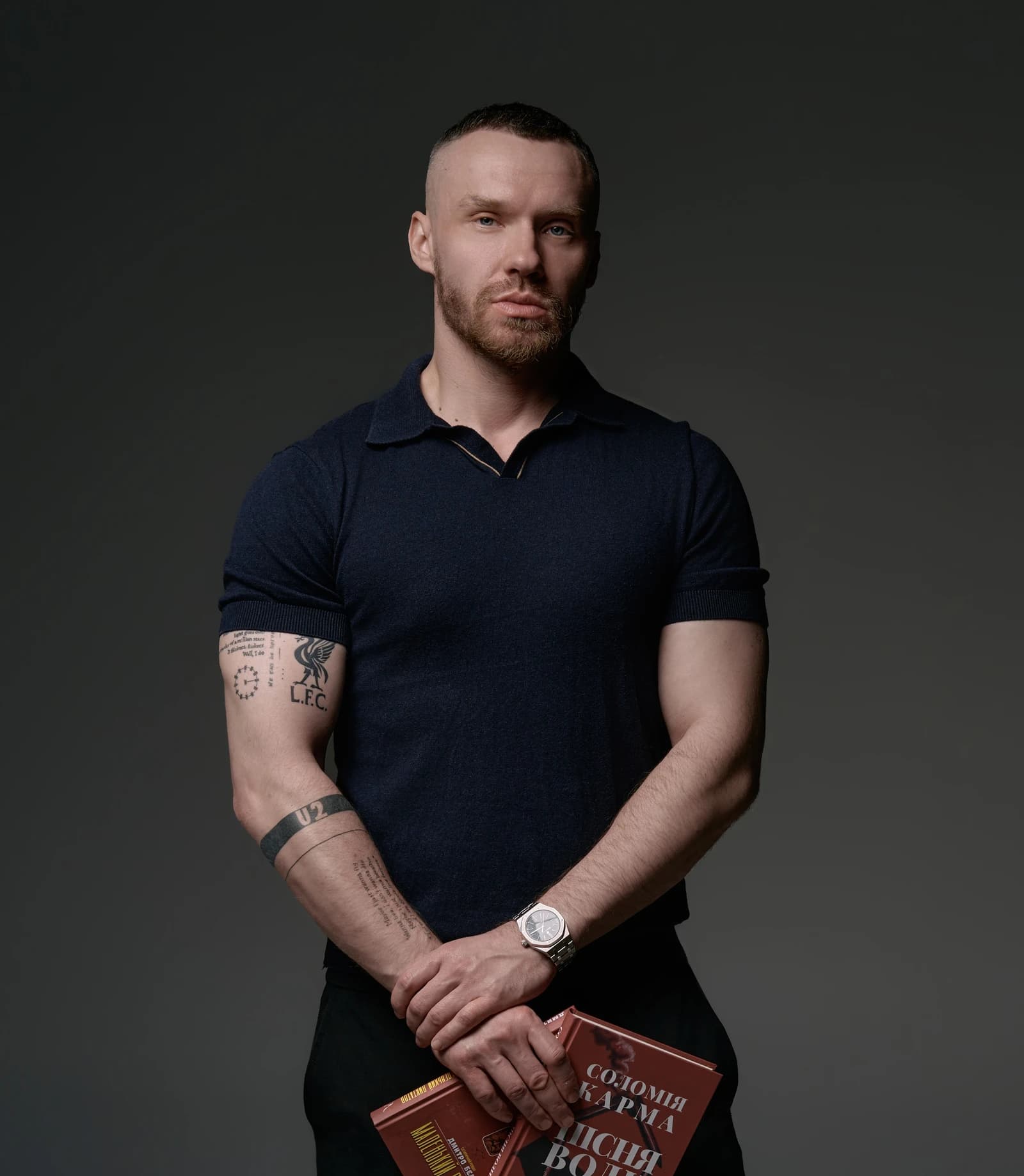 Dmytro Bielov holding books during a book presentation.