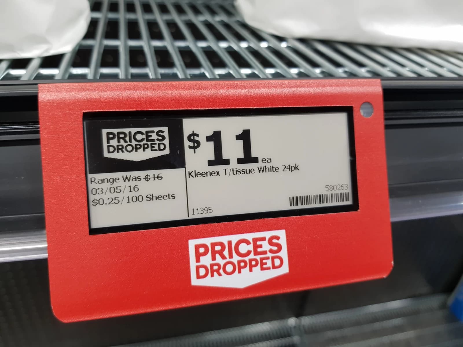 Electronic price tag displaying $11 for Kleenex tissue in a supermarket.