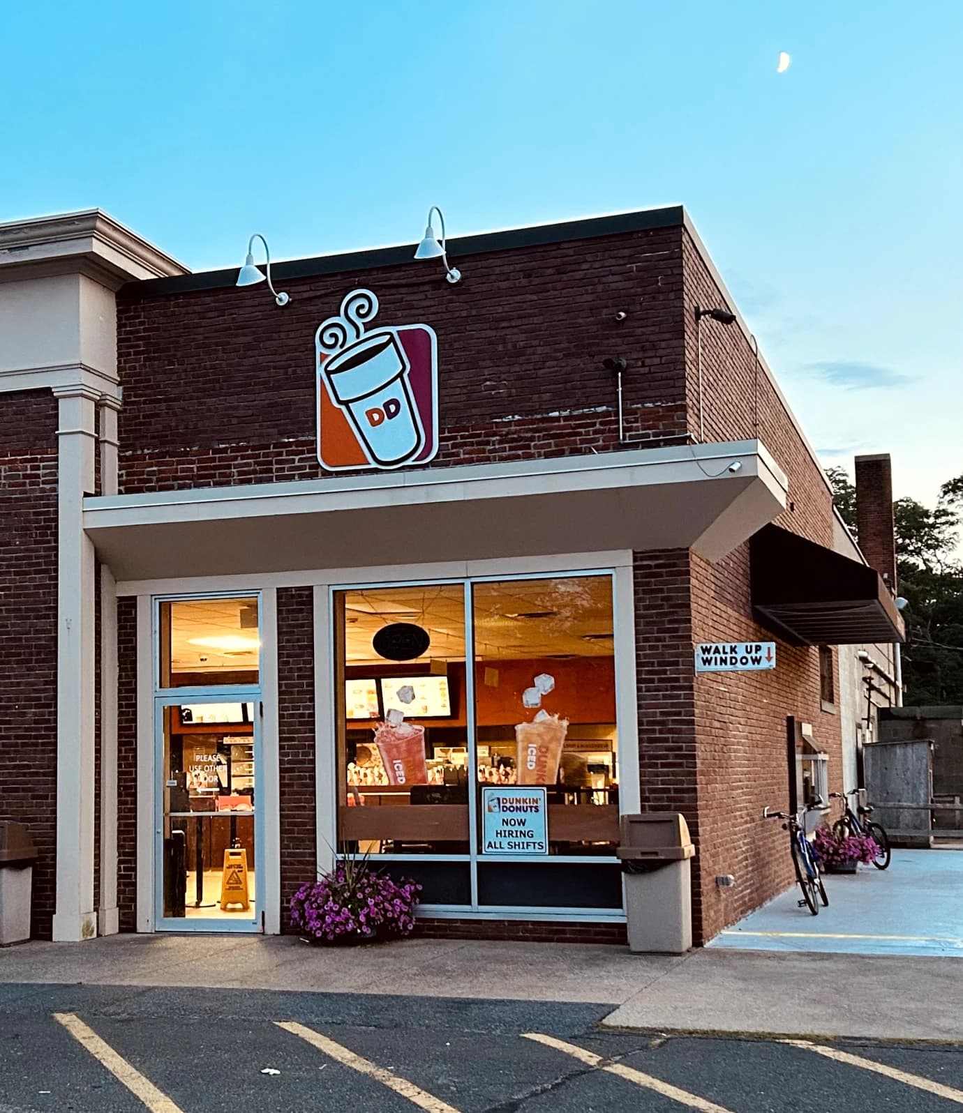 Exterior of a Dunkin' Donuts storefront, with the company's logo on the brick facade.